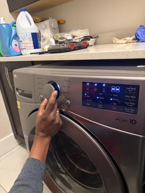 Technician adjusting the controls on a front-loading washer